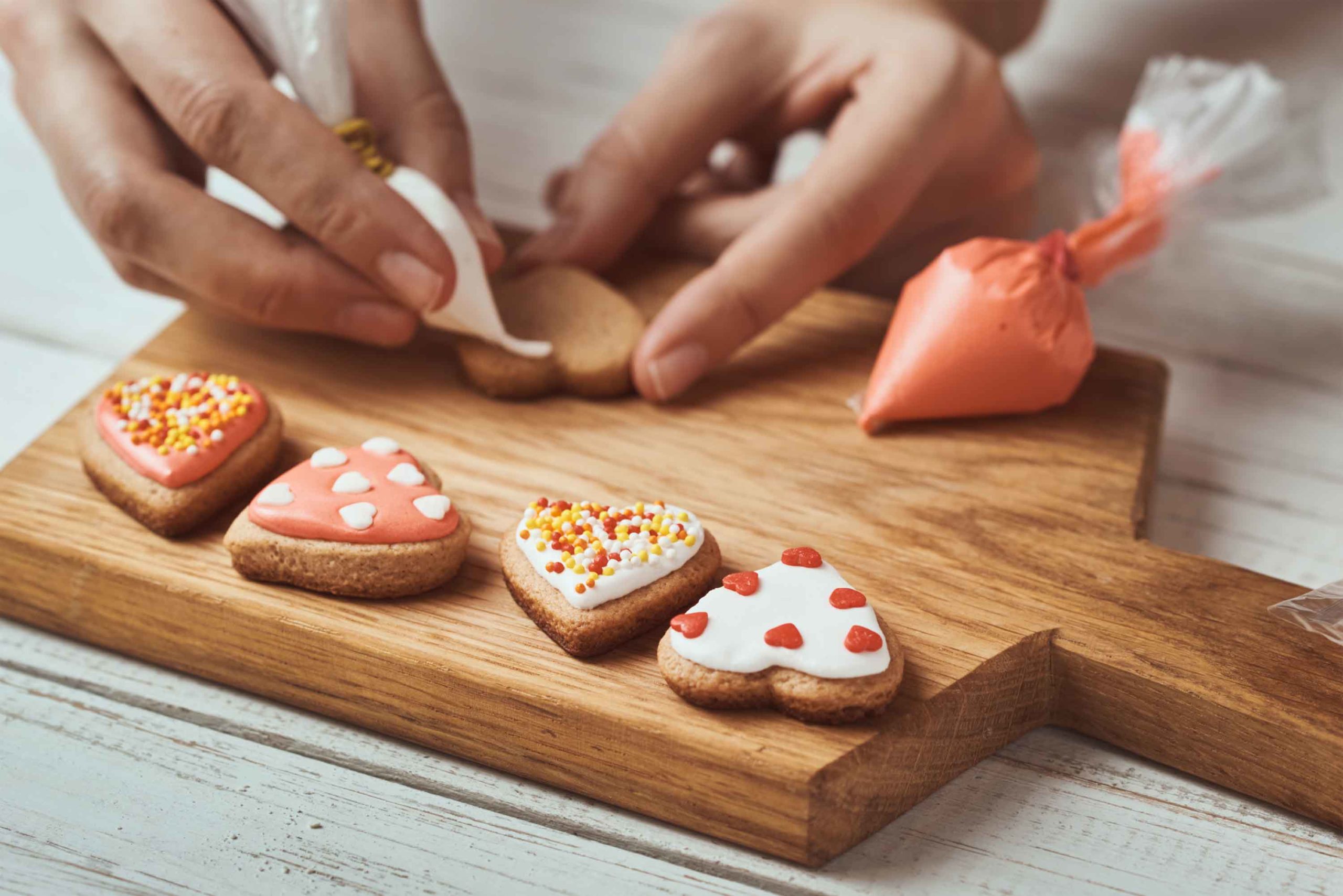 decorating-heart-shaped-cookies-with-icing-and-spr-20-10409460