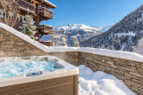 Jacuzzi enneigé face aux montagnes