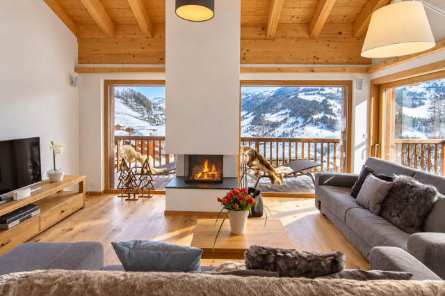 Salon alpin chaleureux, cheminée et neige