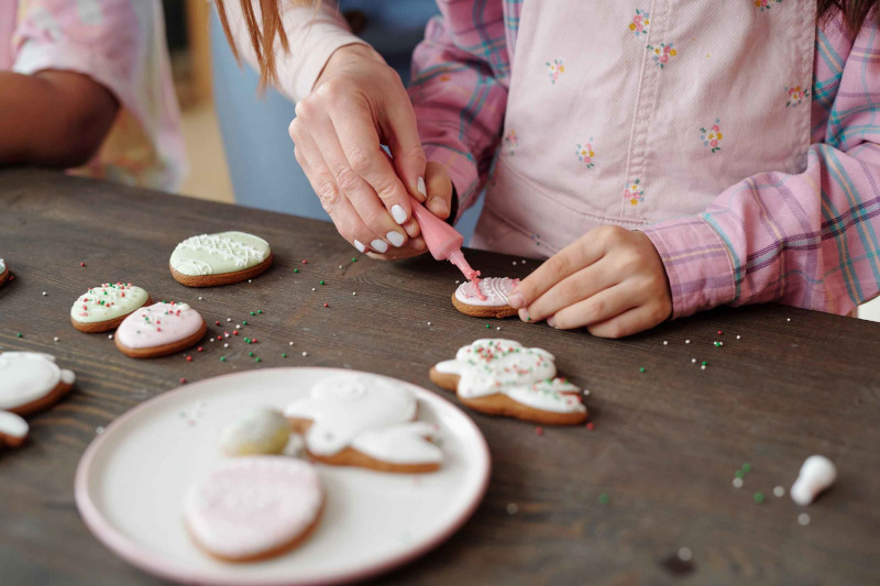 child-and-adult-decorating-festive-cookies-togeth-10409461